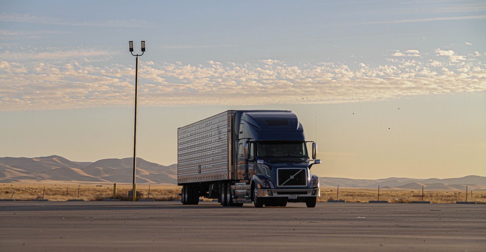 Refrigerated semi-trailer parked at a rest area at dusk
